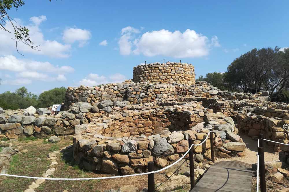 nuraghe,-una-torre-di-pietra-con-attorno-il-villaggio,-dove-rimane-la-pianta-circolare-di-pietre-di-granito