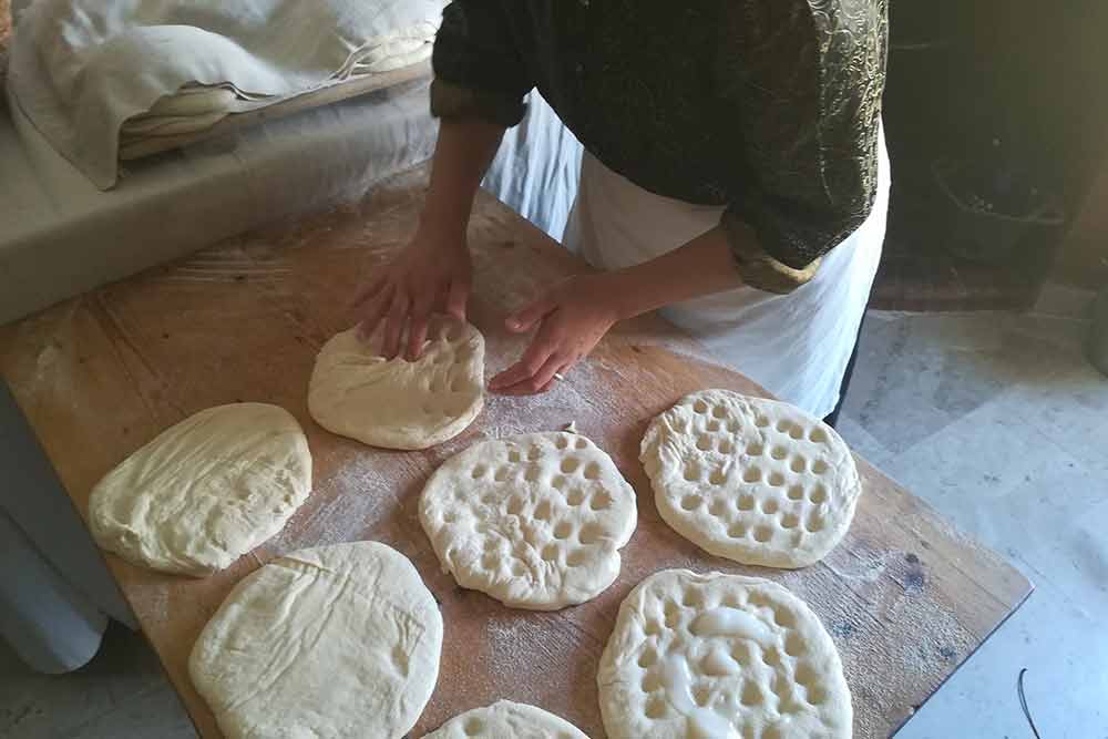 Una signora prepara le focacce