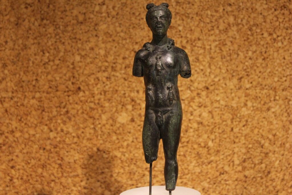 Bronzetto raffigurante Aristeo coperto di api. Gli mancano entrambe le braccia e la gamba destra.