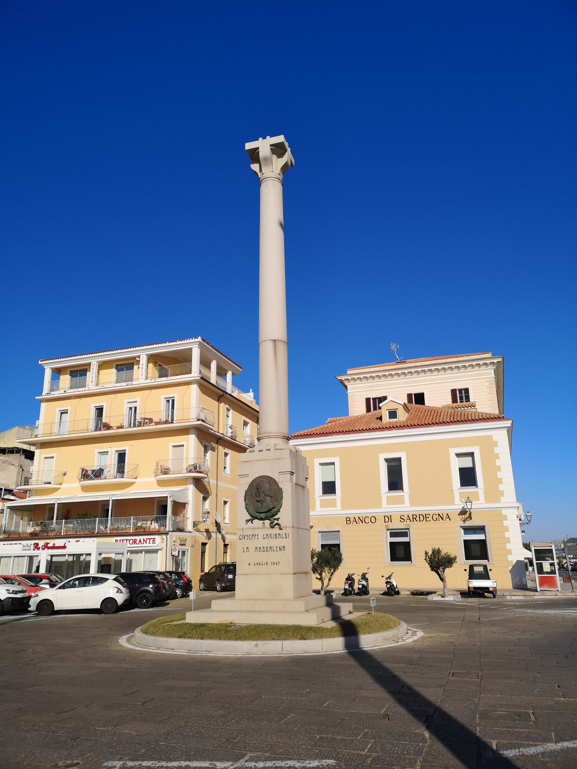 IMG_20210303_154736 Al centro di una piazza sul porto, davanti ai palazzi si trova una colonna in granito con basamento quadrato, con in cima un capitetello. Nel basamento sono presenti in bronzo lo stemma cittadino e l'immagine di garibaldi