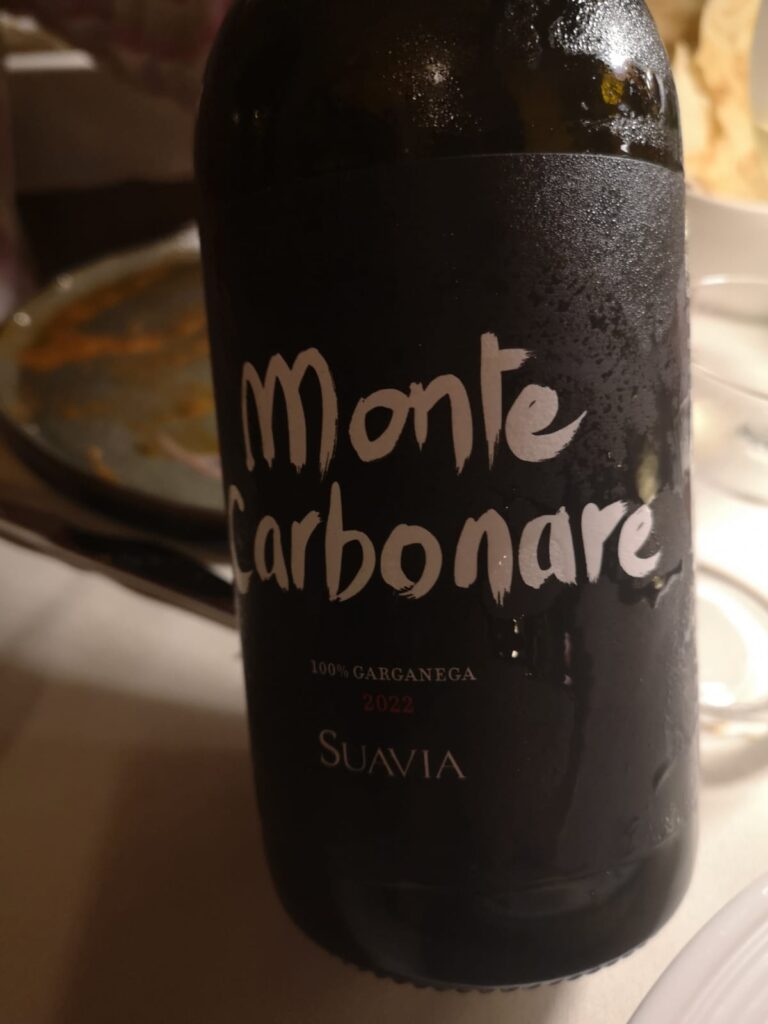 La bottiglia con scritto in corsivo su etichetta nera il nome del vino: Monte Carbonare. Sotto 100% Garganega, 2022, nome cantina SUAVIA.